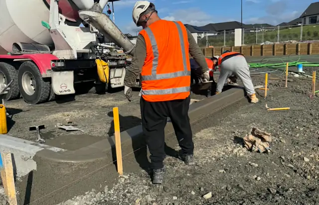 Crew hand-finishing a boxed in-situ concrete pour